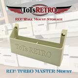 A beige plastic wall mount and storage bracket shown against a blurred background of white drawers, with ToTs RETRO branding and text overlays reading 'ToTs RETRO REU WALL MOUNT/STORAGE' and 'REU/TURBO MASTER MOUNT'.